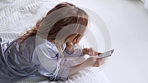 Young woman uses a smartphone, communicating in the instant messengers and use the mobile app