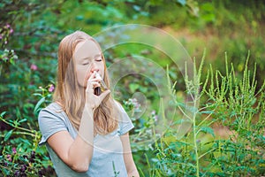 Young woman uses a spray from an allergy because of an allergy to ragweed