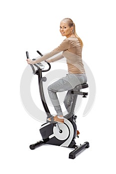 Young woman uses stationary bicycle trainer.