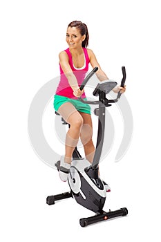 Young woman uses stationary bicycle trainer.