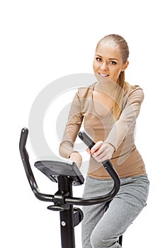 Young woman uses stationary bicycle trainer.