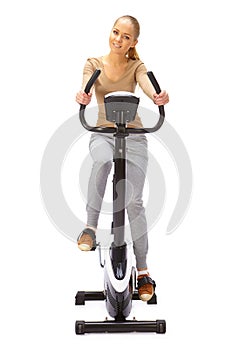 Young woman uses stationary bicycle trainer.