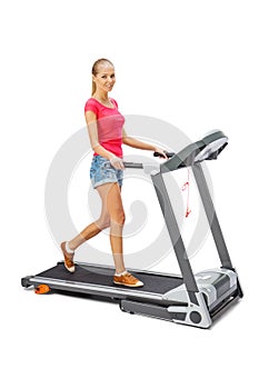 Young woman uses treadmill.