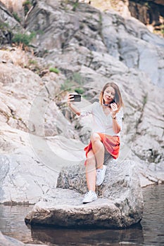 Young woman usin smartphone on the lake