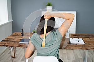 Woman Using Back Scratcher