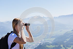 Young woman using binoculars during an hike
