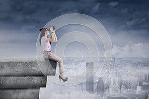 Young woman using binoculars on rooftop