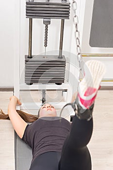 Young woman using cable crossover machine at gym