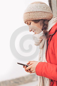 Young woman using cell phone texting, typing and smiling