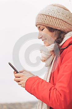 Young woman using cell mobile phone typing and smiling