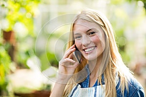 Young woman using cellphone at greenhouse