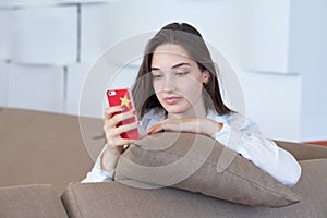 Young woman using cellphone at home