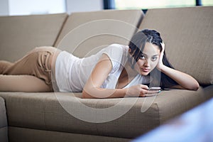 Young woman using cellphone at home