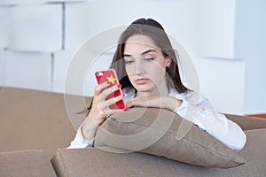 Young woman using cellphone at home