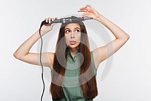 young woman using curling iron isolated