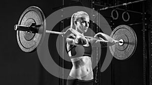 Young woman using curved barbell