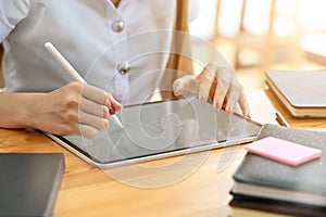 Young woman using digital tablet computer with pen