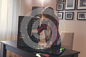 Young woman using electrical screwdriver to fix a computer
