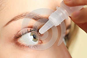 Young woman using eye drops on light background, closeup