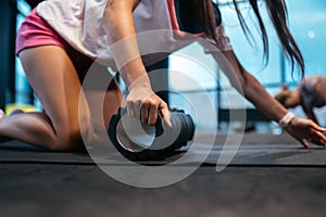 Young woman using a foam roller while doing stretching exercises