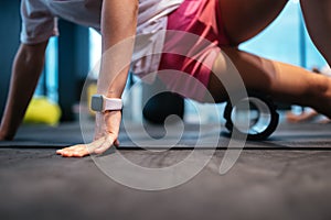 Young woman using a foam roller while doing stretching exercises