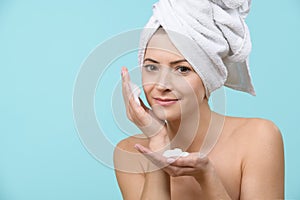 Young woman using gentle foam facial cleanser. Attractive woman washing her face with foam soap.