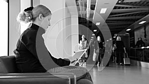 Young woman using her digital tablet pc at an airport lounge