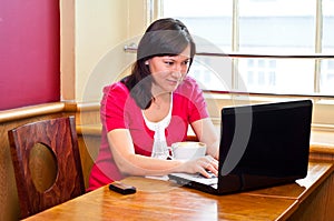 Young woman using her laptop in a cafe