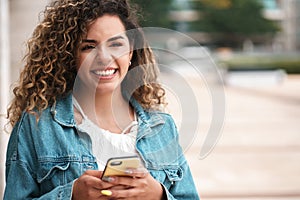 Young woman using her mobile phone outdoors on the street.