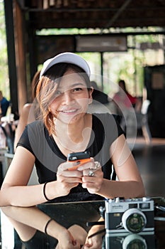 A young woman is using her smart phone , while is sitting in res