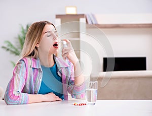 Young woman using inhalator to cope with asthma