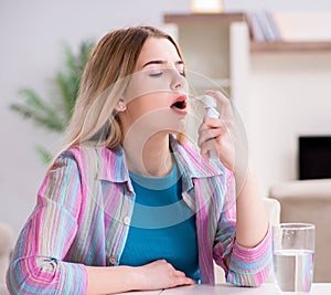 Young woman using inhalator to cope with asthma