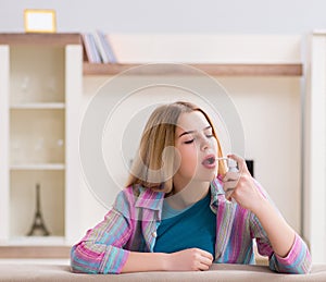 Young woman using inhalator to cope with asthma