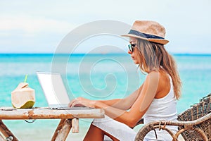 Young woman using laptop on the beach. Freelance work