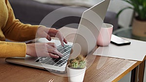 Young woman using laptop and coffee cup pink working in the office