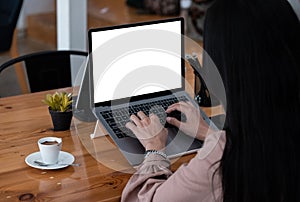 Young woman using laptop computer with blank white screen for business working at cafe