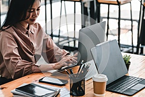 Young woman using laptop computer for business working at cafe