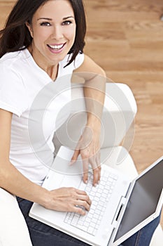 Young Woman Using Laptop Computer At Home on Sofa