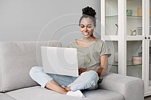 Young woman using laptop computer at home. Student girl working in her room. Work or study from home concept