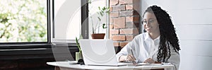 Young woman using laptop computer at office panoramic banner. Student girl working at home. Freelance concept