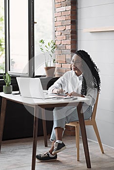 Young woman using laptop computer at office. Student girl working at home. Work or study from home, freelance, e-learning concept