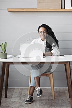Young woman using laptop computer at office. Student girl working at home. Work or study from home, freelance, lifestyle concept
