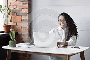 Young woman using laptop computer at office. Student girl working at home. Work or study from home, freelance, lifestyle concept