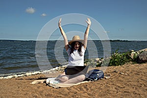 Young woman using laptop computer on sunbed on a beach. Freelance work concept, Freelancer outside