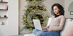 Young woman using laptop at home during Christmas holiday