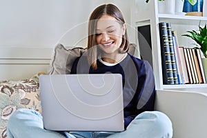 Young woman using laptop sitting on sofa at home