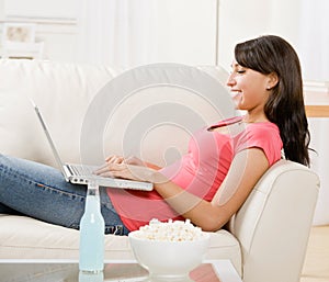 Young woman using laptop on sofa at home