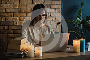 Young woman using laptop to work at home during electricity outage. Remote work at home concept. Freelancer working at the