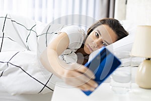 Young woman using mobile phone on bed
