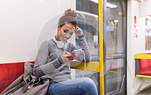 Young woman using mobile phone on subway